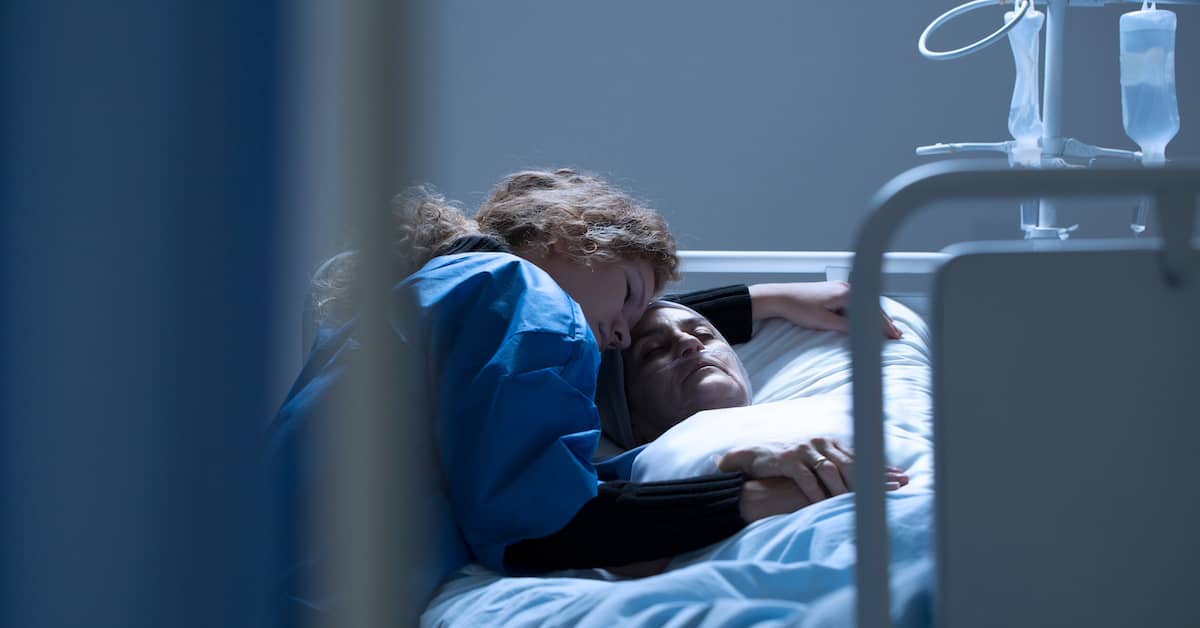 woman hugs patient in hospital bed - personal injury lawyer